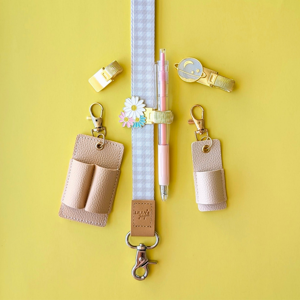 Leather keychains, lanyard, and pen on a yellow background