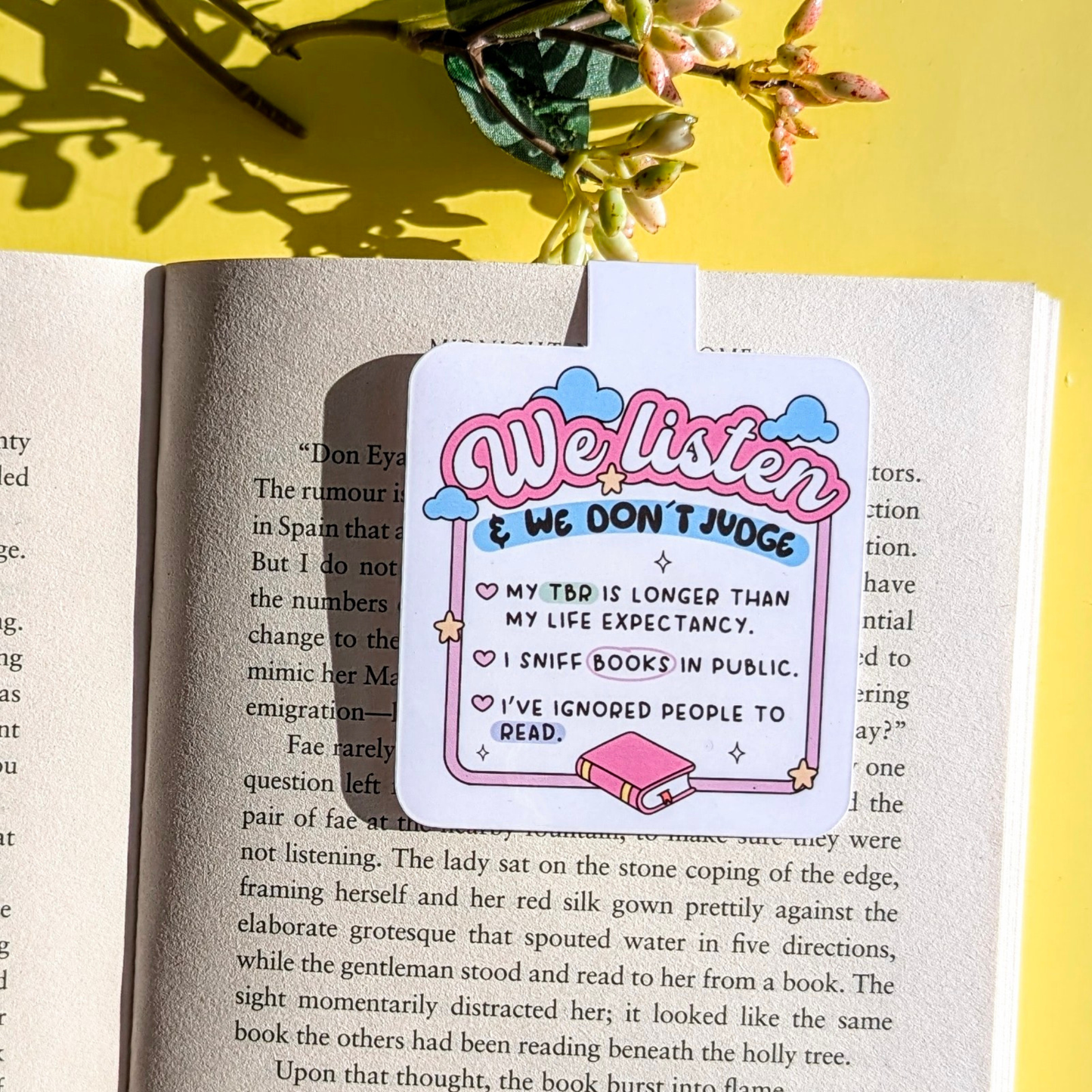 Sticker with 'We Listen & We Don't Judge' text on an open book with a yellow background