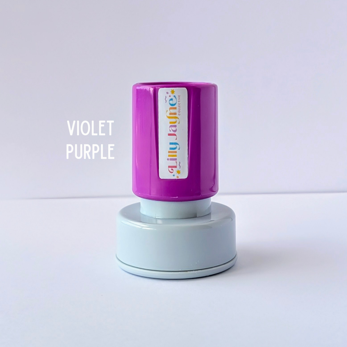 Purple stamp with 'Lilly Jayne Collective' branding on a light grey background
