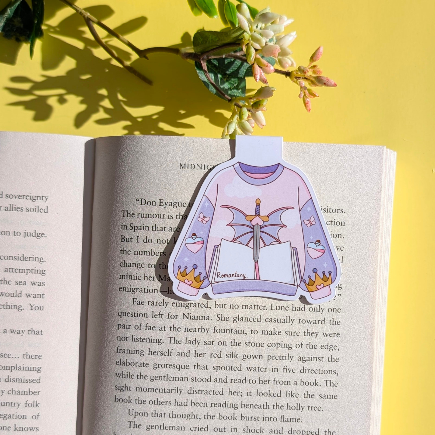 Book with a colorful sweater design bookmark on a yellow background