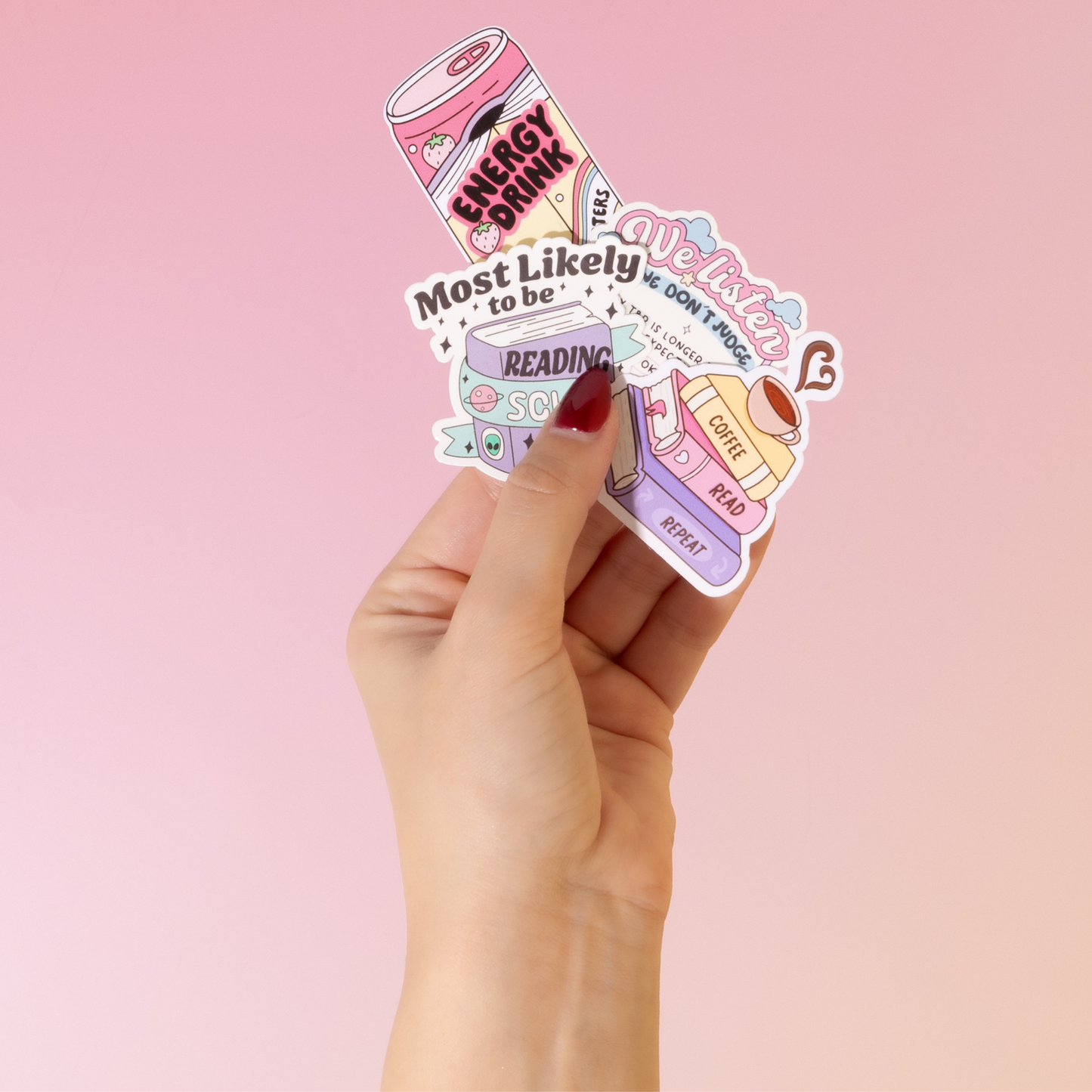 Hand holding a set of colorful stickers with text on a pink background