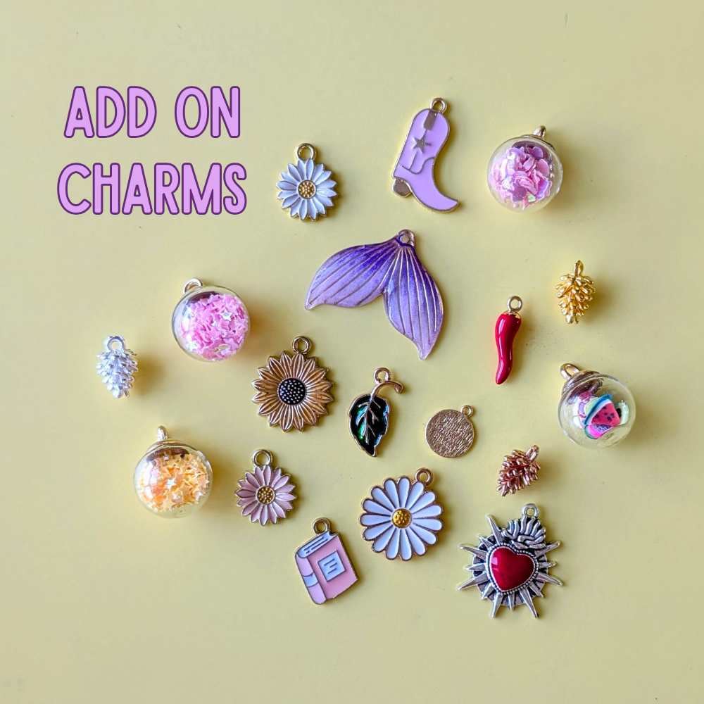 Collection of various charms on a yellow background with 'ADD ON CHARMS' text.