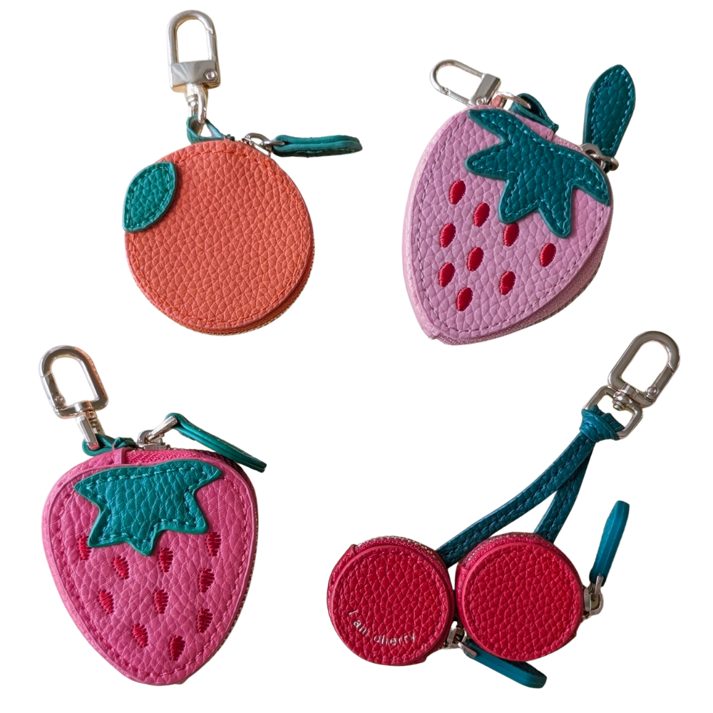 Set of four fruit-shaped keychains on a white background