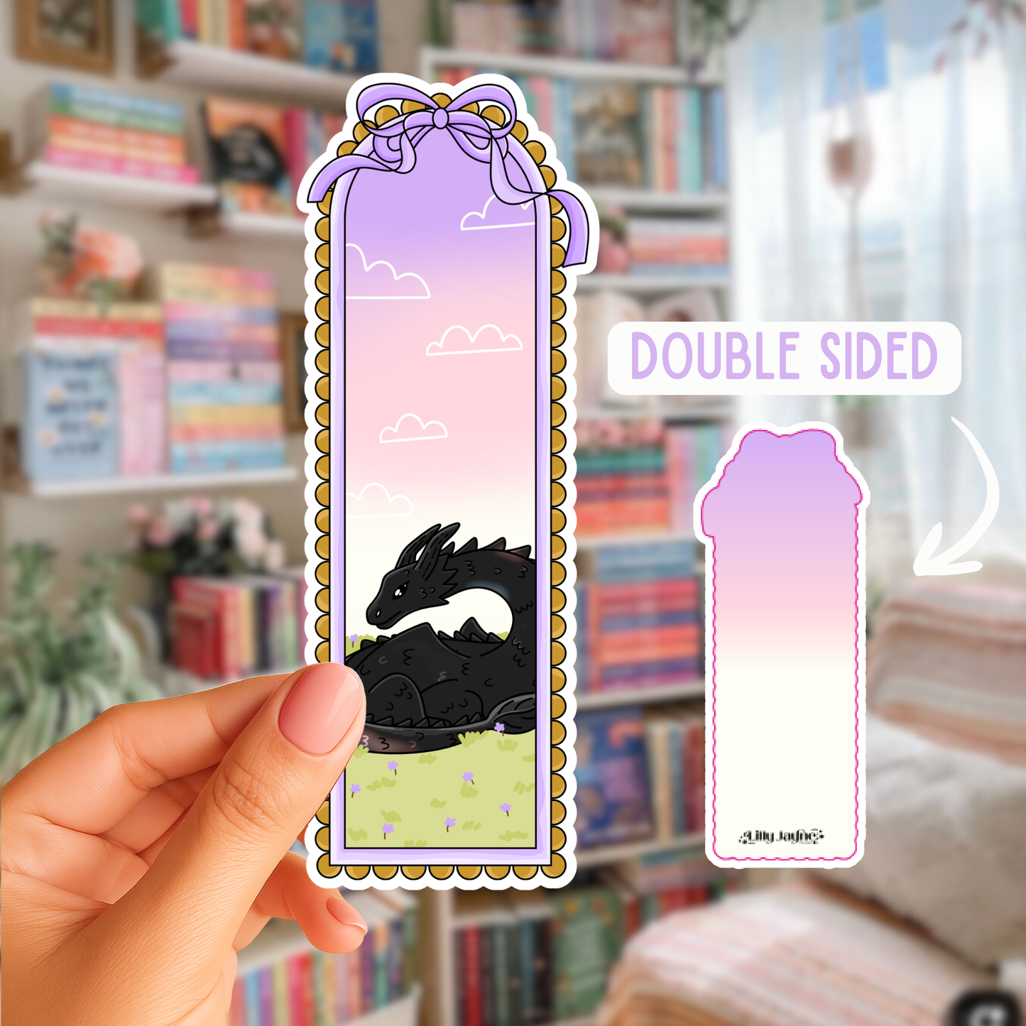 Double-sided bookmark with dragon illustration held by a hand in a room with bookshelves.
