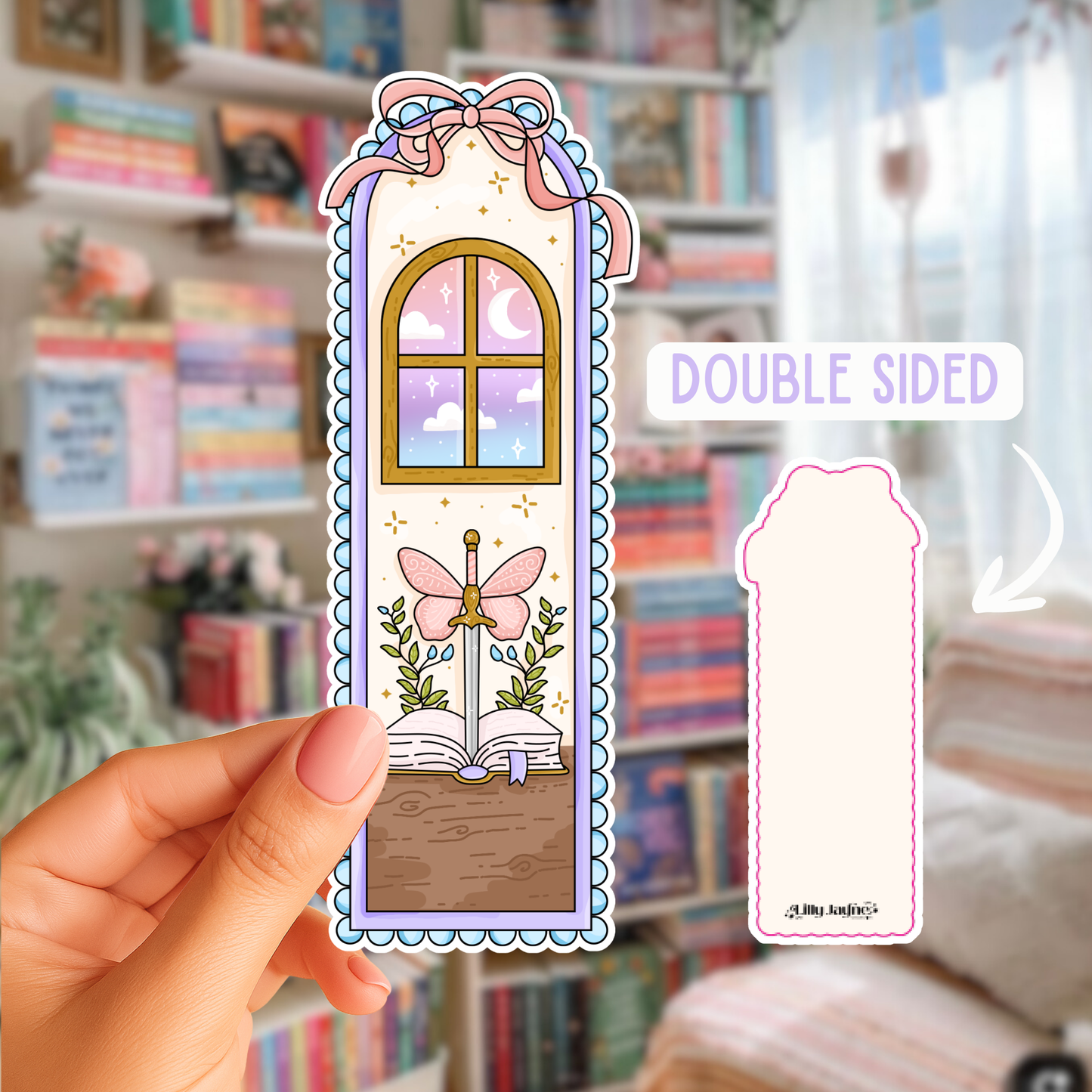 Decorative bookmark with a fairy and butterfly design held by a hand in front of a bookshelf.
