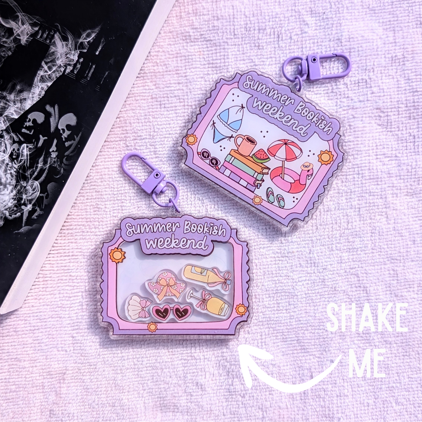 Two purple 'Summer Bookish Weekend' themed containers on a textured surface with 'SHAKE ME' text.