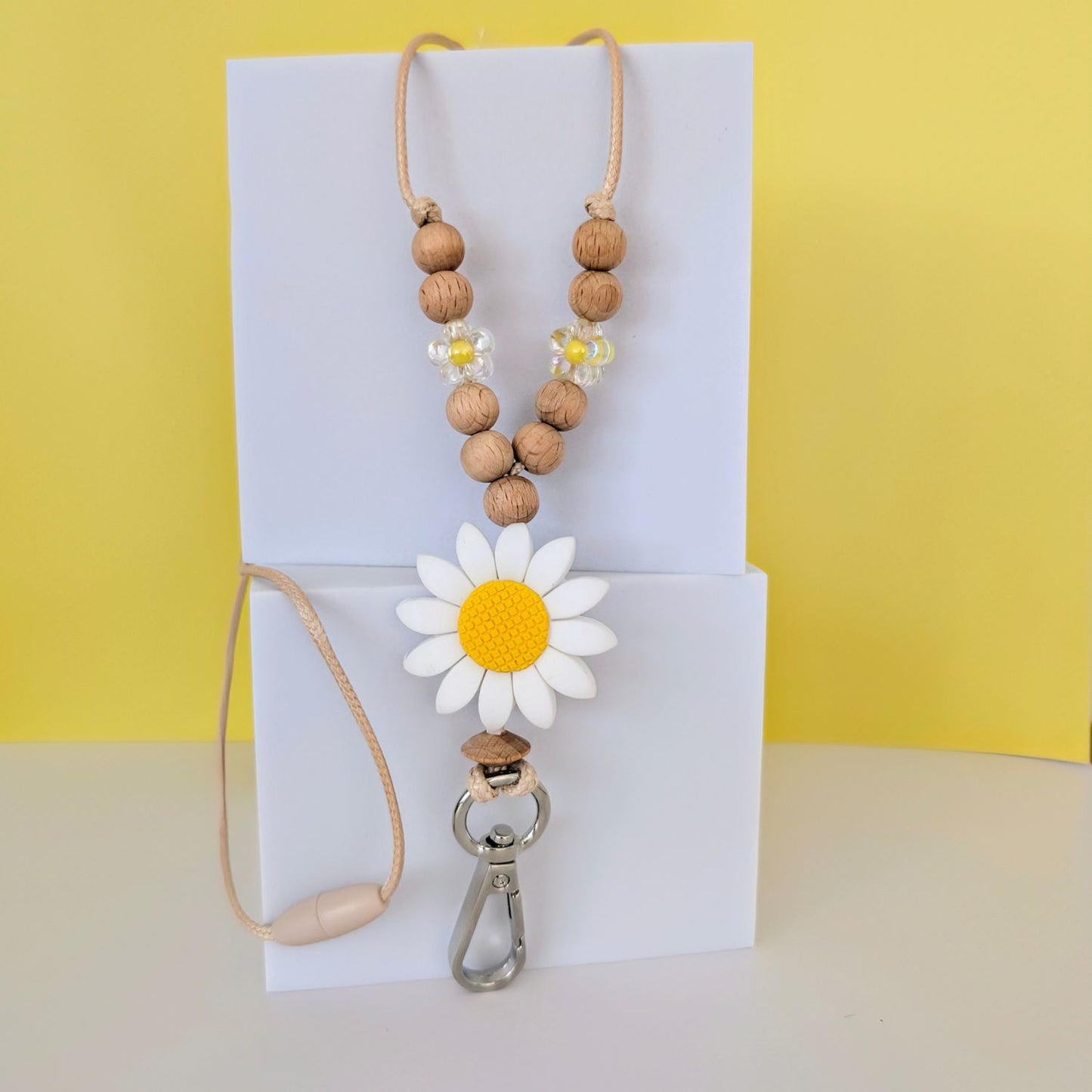 White Flower Beaded Lanyard. Large White Flower silicone bead with yellow centre. Wooden beads and acrylic flower bead. with a silver clip