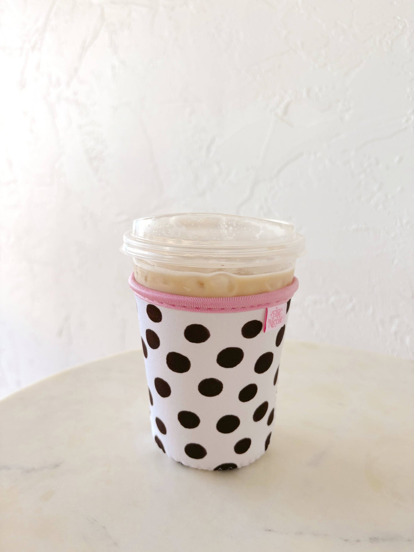 Stack of cups in a polka dot sleeve on a white surface