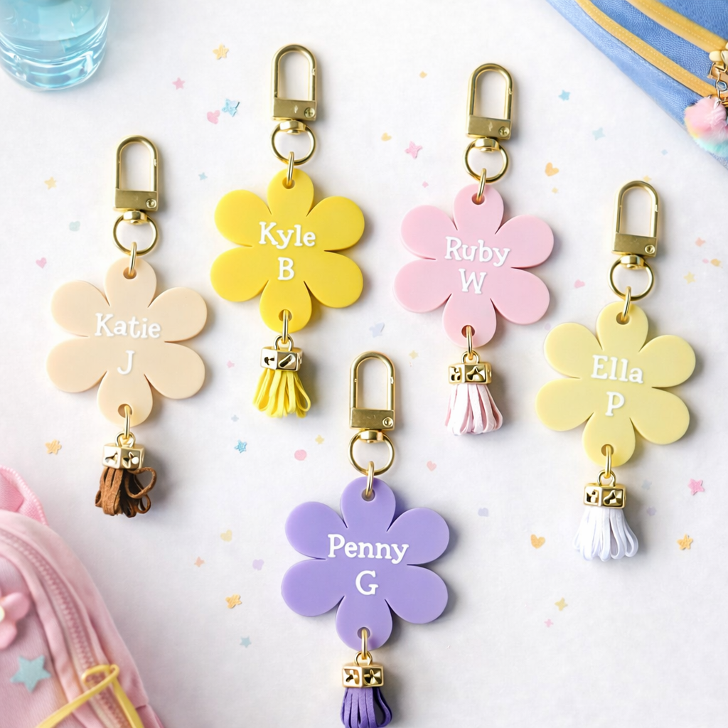 Set of colorful flower-shaped keychains with names on a light background