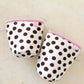 Pair of polka dot baby booties with pink trim on a light background