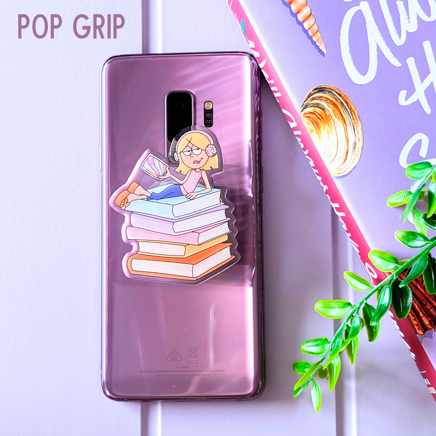 Phone case with cartoon character on a stack of books, brand 'Pop Grip' visible