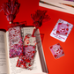 Decorative bookmarks and stickers with 'Smutty Book Lover' design on a red background.