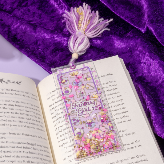 Decorative bookmark with 'Fantasy Girls' text on an open book with a purple fabric background.