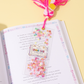 Open book with a decorative page featuring a small book and pink confetti on a yellow background.