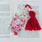 Decorative bookmark with red yarn and 'Smutty Book Lover' design on a book page.