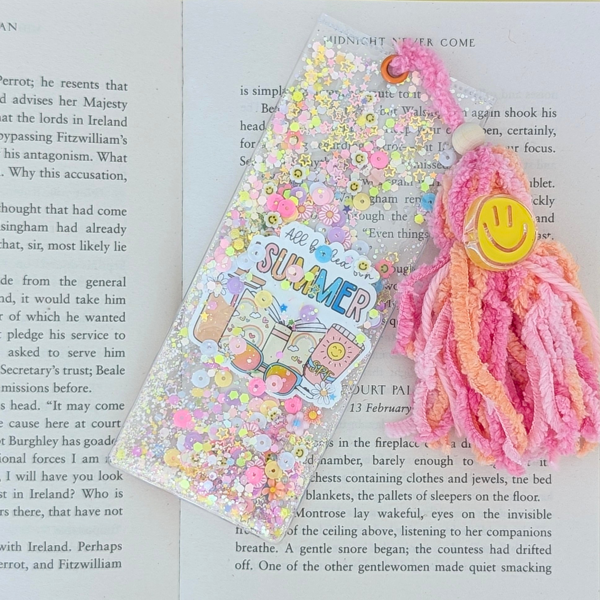 Decorative bookmark with pink hair accessory on a book page