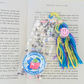Colorful tassel bookmark with a smiley face on an open book