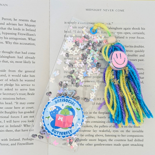 Colorful tassel bookmark with a smiley face on an open book