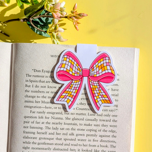 Checkered bow bookmark on an open book with a yellow background