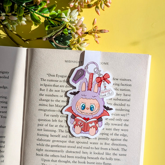 Anime character keychain on an open book with a yellow background