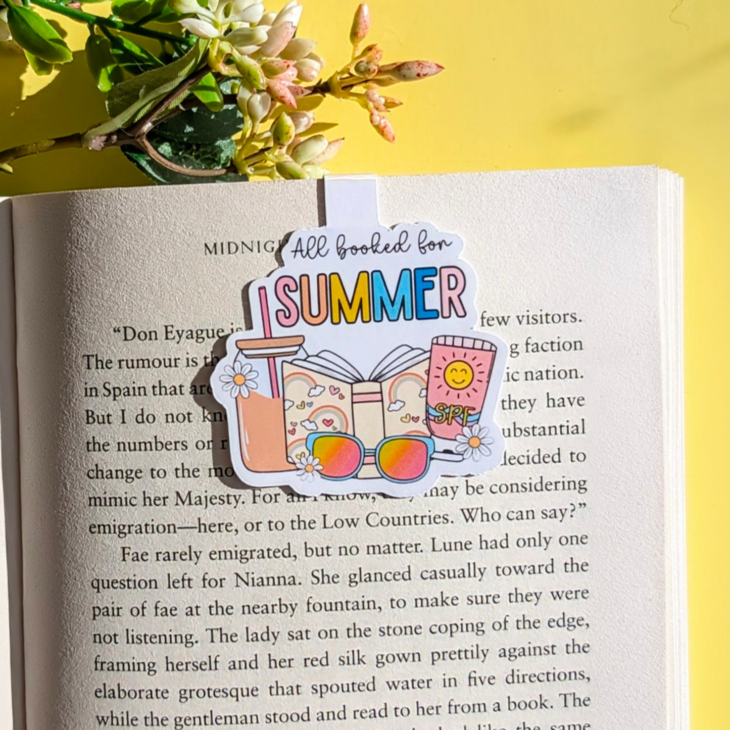 Book with a 'Summer' themed bookmark on a yellow background