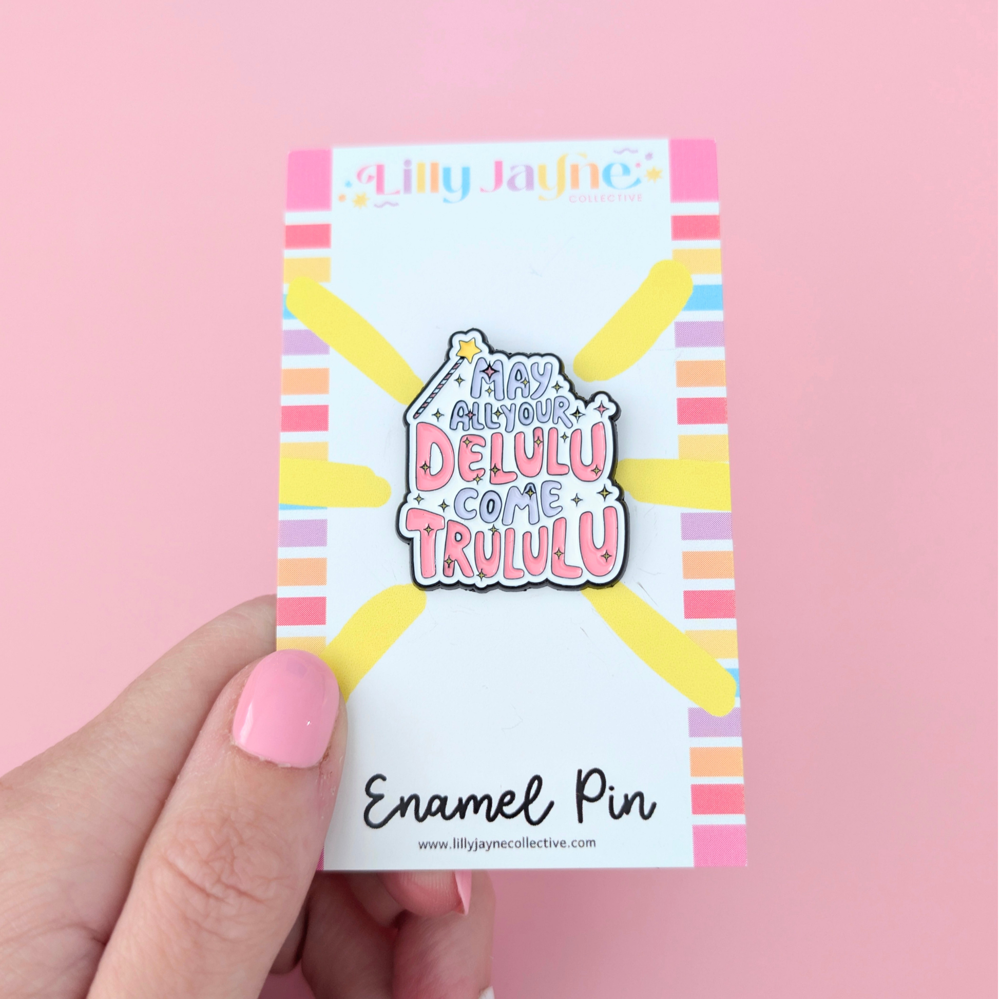 Enamel pin packaging with colorful design and text on a pink background