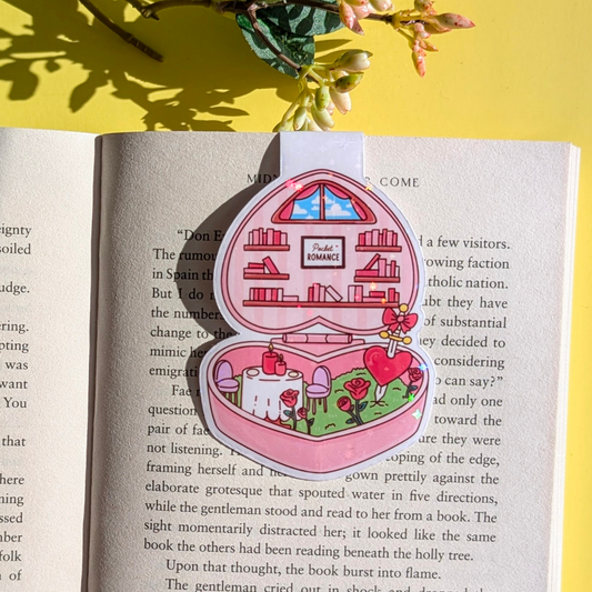 Decorative pink jewelry box with a house design on an open book