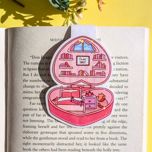 Pink heart-shaped jewelry box with a miniature bedroom scene on an open book
