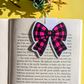 Plaid bow sticker on an open book with a yellow background