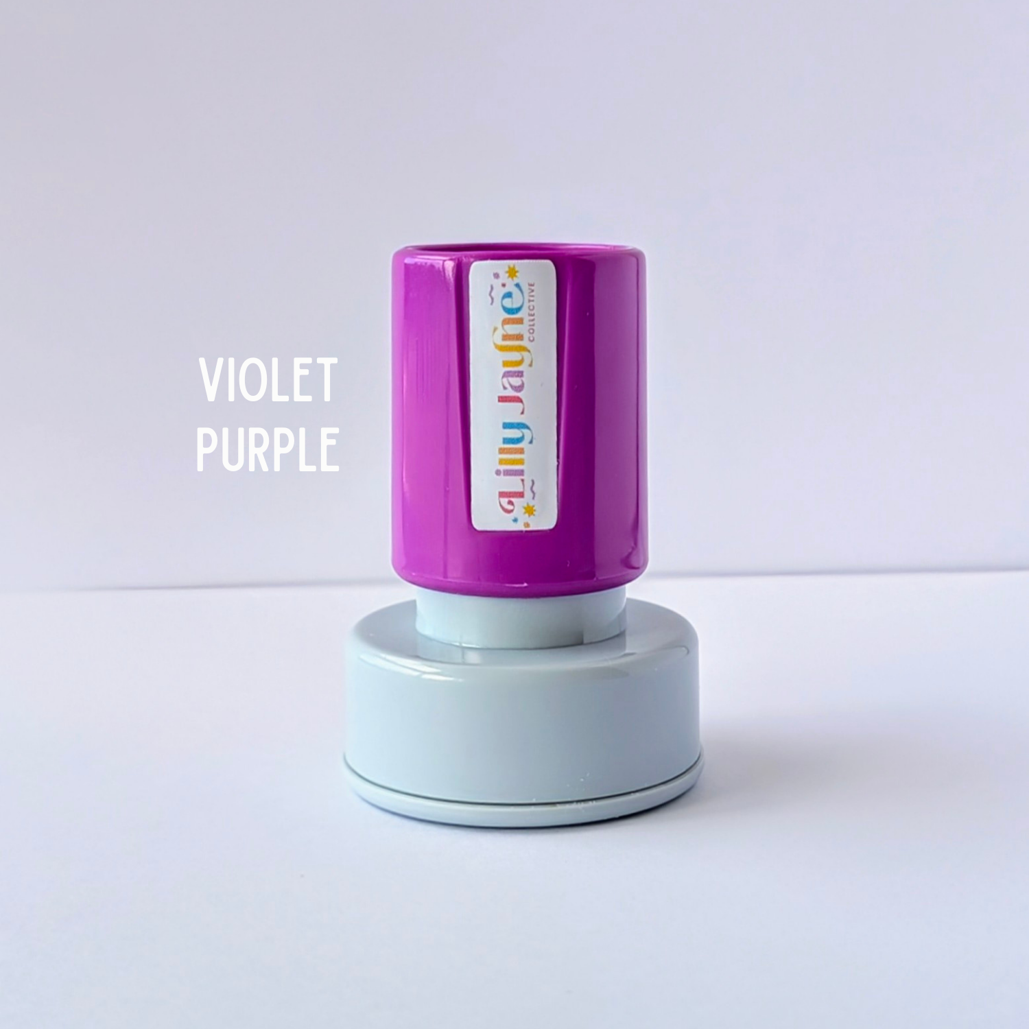 Purple stamp with 'Lilly Jayne Collective' branding on a light grey background