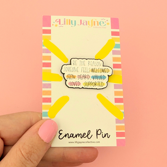 Enamel pin packaging with colorful design and text on a pink background