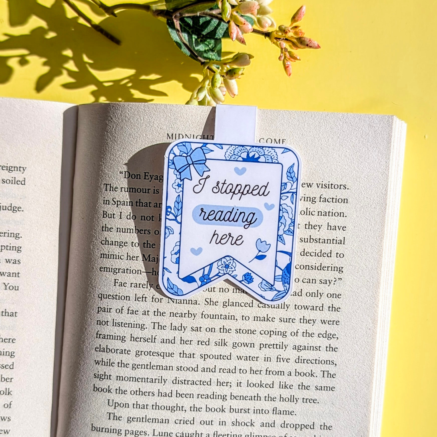 Book with a bookmark that says 'I stopped reading here' on a yellow background