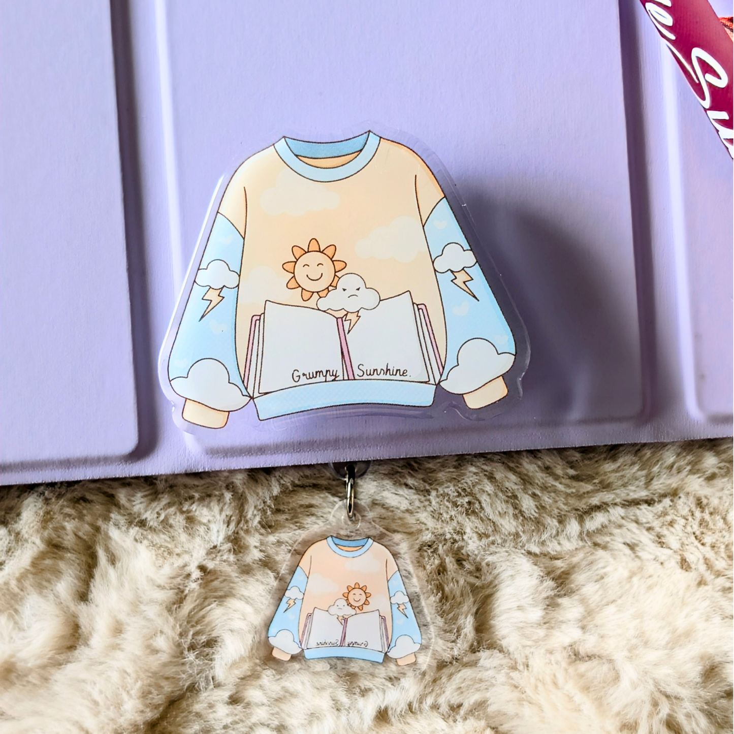 Decorative keychain with a cartoon sweatshirt design on a textured surface