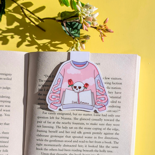 Sweater design with skull and roses on a book page with yellow background