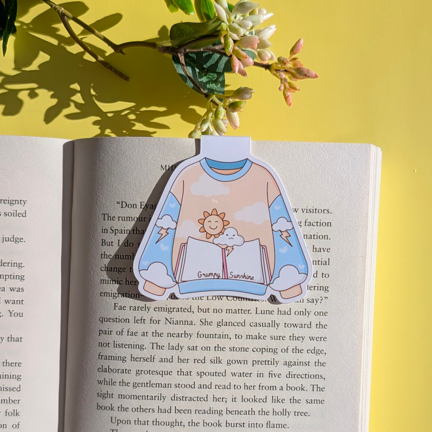 Open book with a sticker of a person wearing a sweatshirt with a sun design on a yellow background