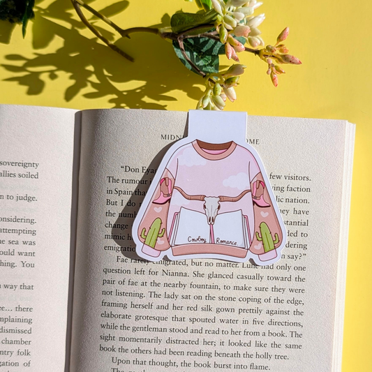 Sticker of a shirt with a graphic design on an open book with a yellow background