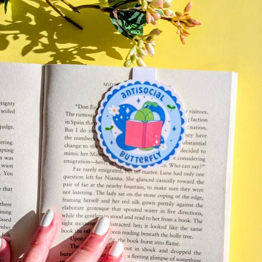 Book with a 'antisocial butterfly' sticker on a yellow background