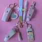 Collection of keychains and pouches on a pink background