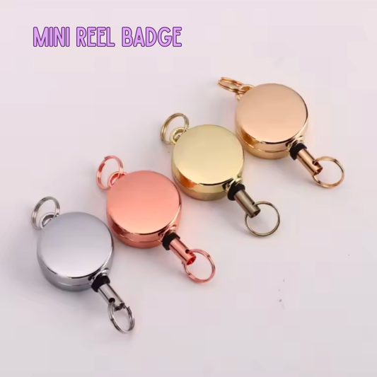 Mini reel badge in gold, rose gold, and silver on a white background