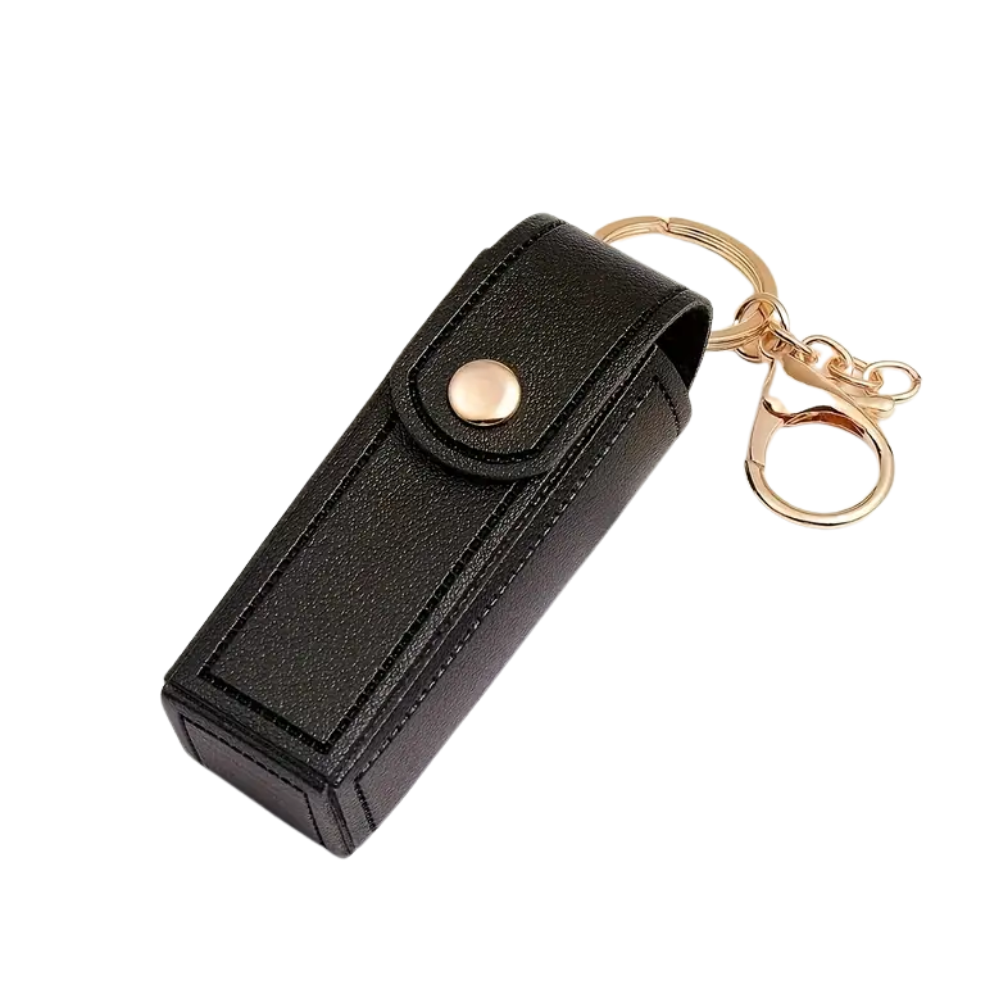 Black leather key case with gold keychain on a white background