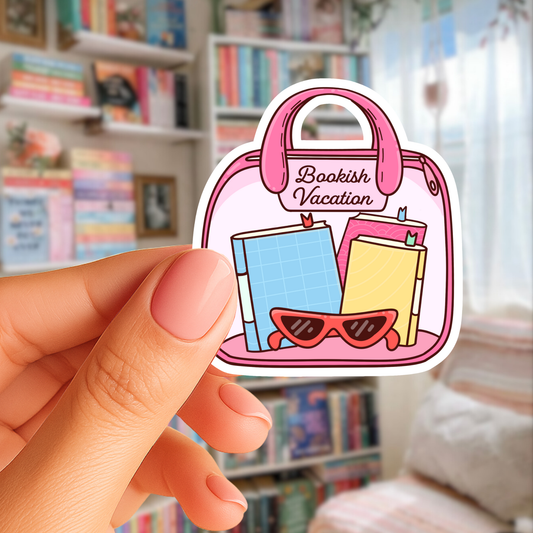 Sticker of a pink bag labeled 'Bookish Vacation' held by a hand in front of a bookshelf.