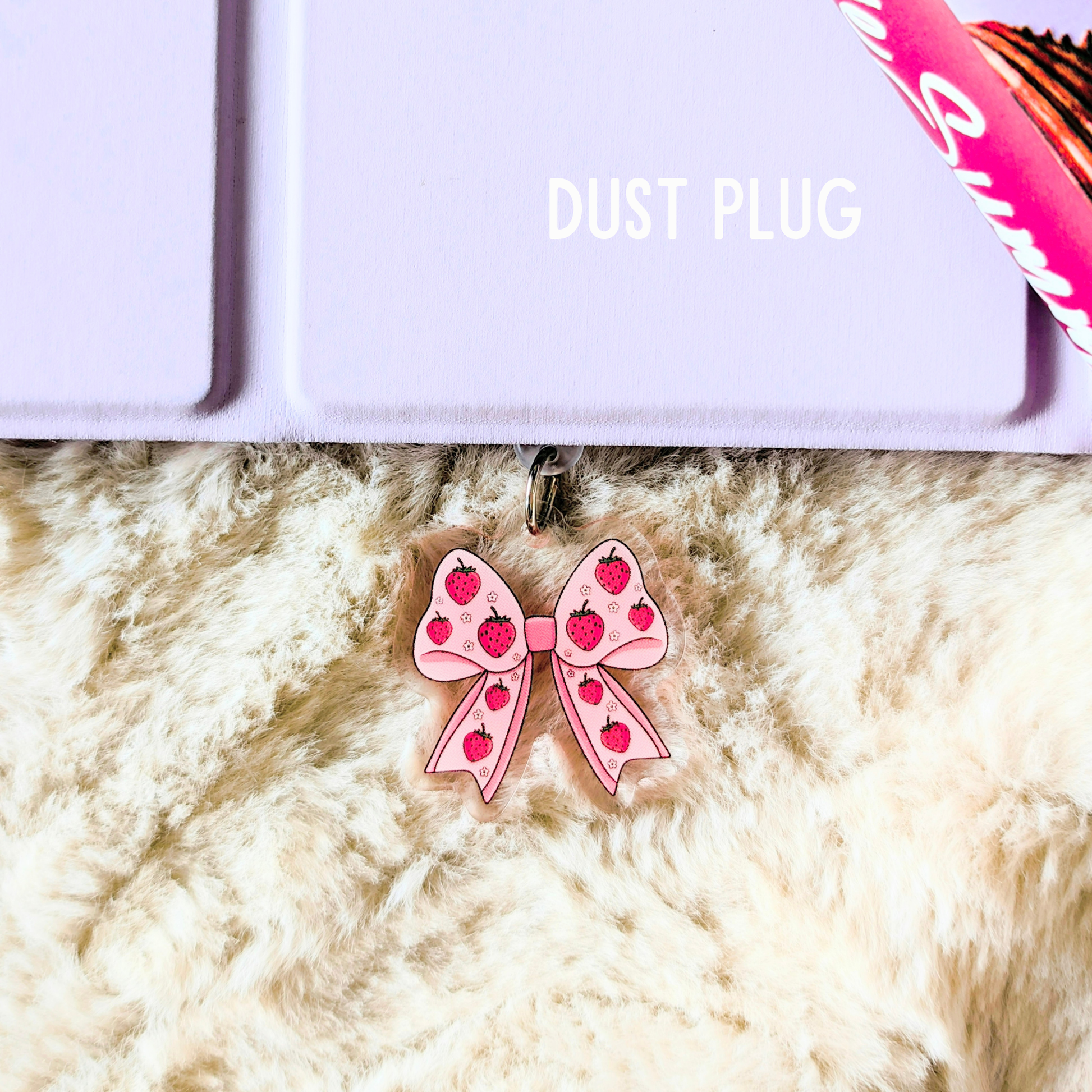 Pink bow with red hearts on a fluffy white surface, with 'DUST PLUG' text above.
