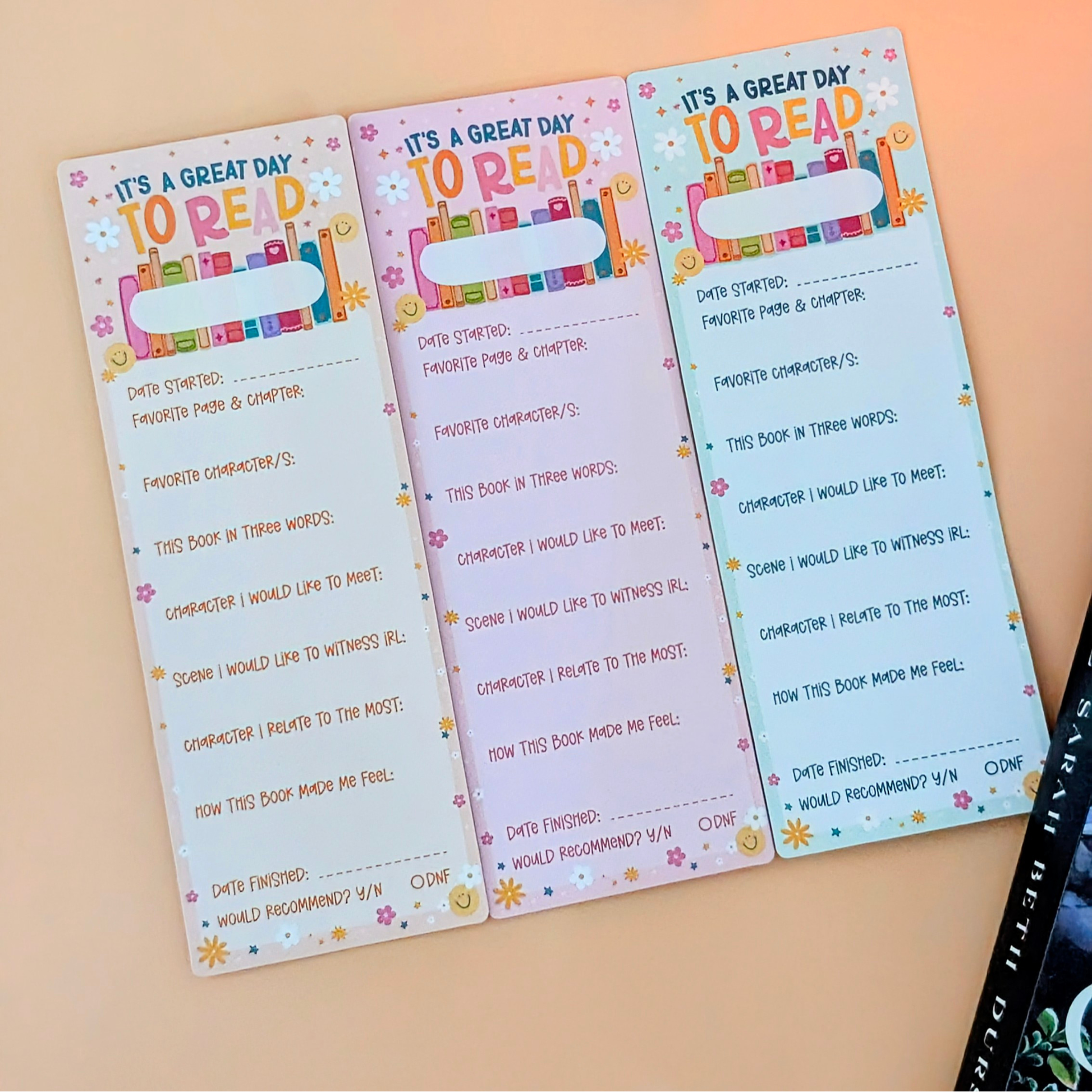 Three colorful reading logs on a beige background