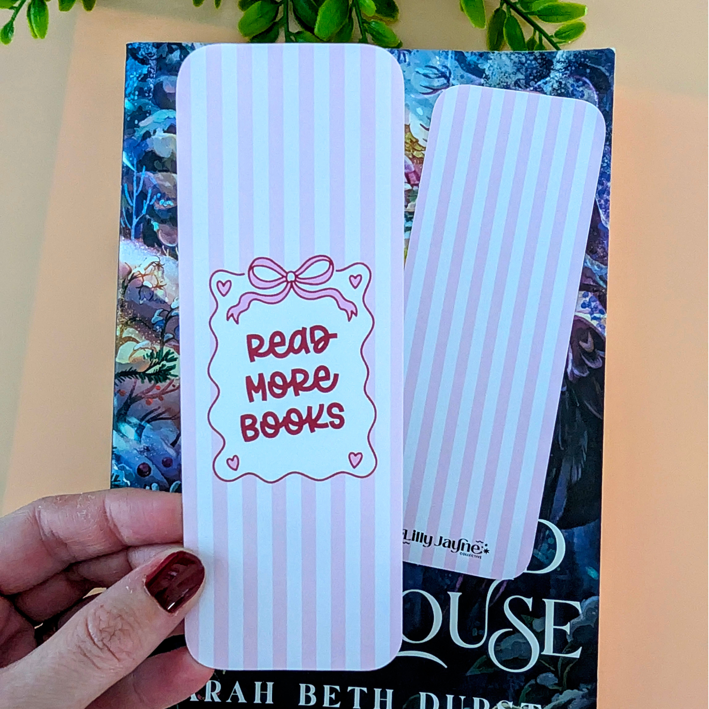 White bookmark with 'Read More Books' text held over a book