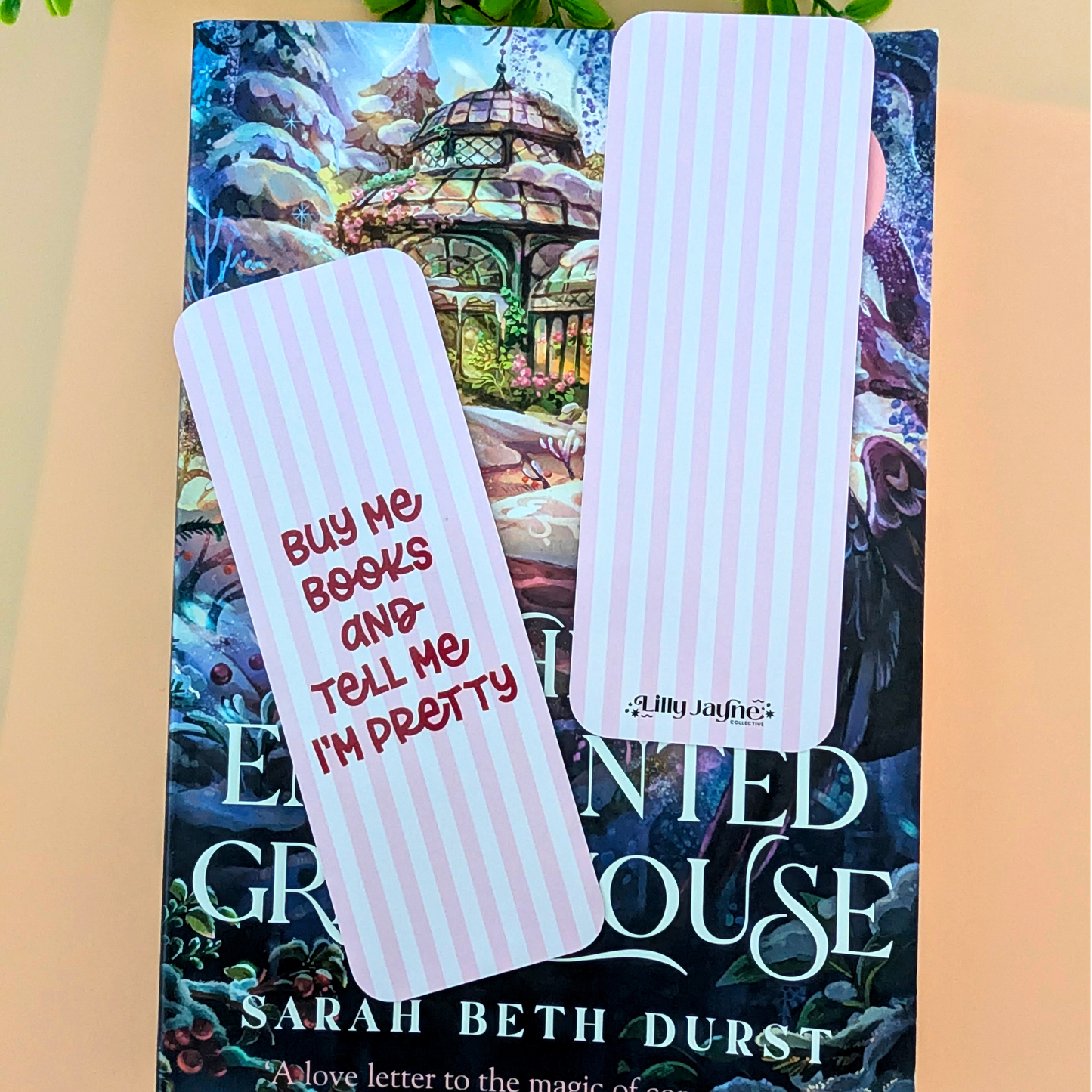 Book with a decorative cover and two bookmarks on a beige surface