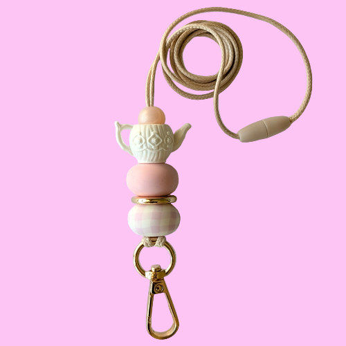 Necklace with pink and beige beads and a gold clasp on a white background