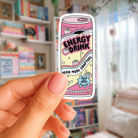 Hand holding a small can-shaped product with 'Energy Drink' text against a blurred indoor background.