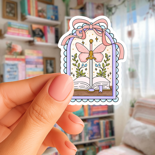 Hand holding a colorful sticker with a butterfly and sword design in a library setting