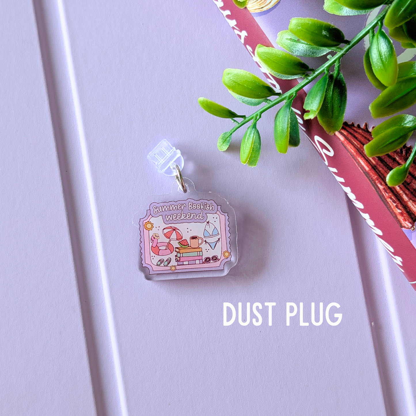 Dust plug with summer-themed design on a light purple surface with green leaves.