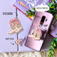 Samsung phone case with pink cowgirl boot design, stickers, and dust plug on a light purple background.